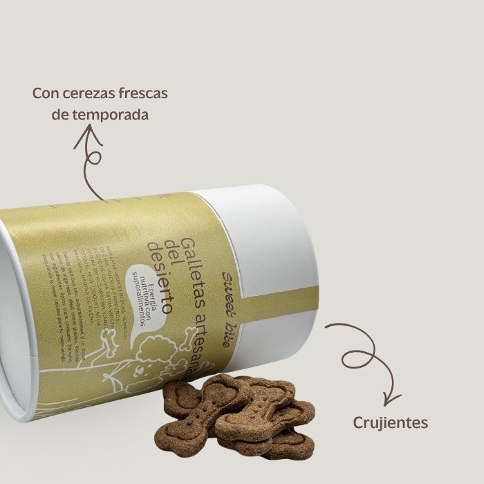Galletas Artesanales para Perros del Desierto Bote inclinado de galletas artesanales para perros del que asoman los snacks en forma de huesito. La imagen subraya que las galletas son crujientes y están elaboradas con cerezas frescas de temporada.