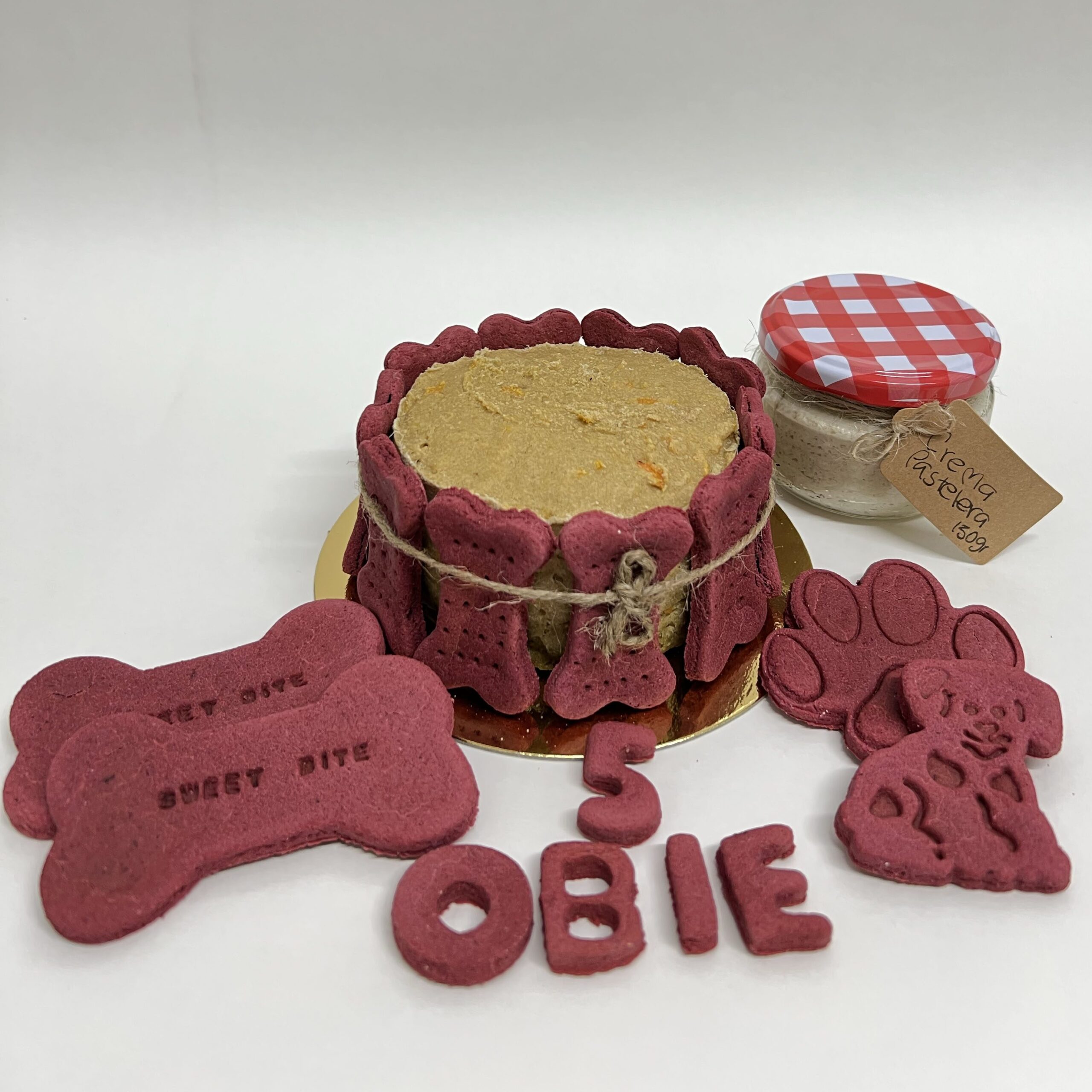 Tarta Cookiesdog Obie Envío Tarta de cumpleaños artesanal para perro hecha de ternera y pollo con galletas rojas de remolacha y miel, nombre personalizado, número de años y crema pastelera para decorar en casa. Envío a domicilio.