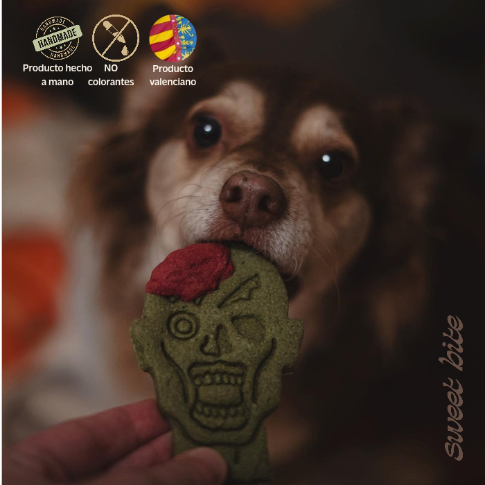 Galletas Naturales de Halloween para Perros - Pack Zombie Perro disfrutando de nuestras galletas naturales de Halloween para perros con forma de cabeza de zombie. Destacan los sellos de elaboración artesanal valenciana y sin colorantes.