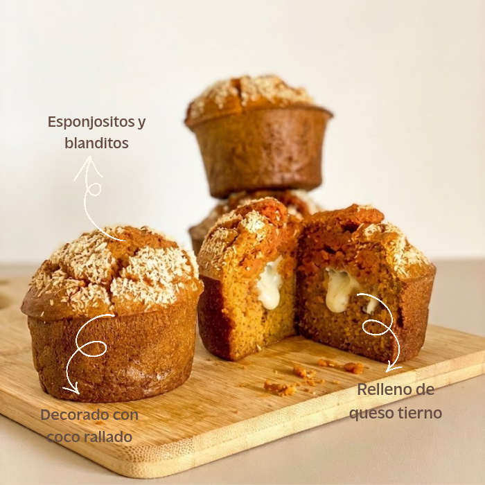 Muffins de Calabaza y Queso para Perros - Edición Halloween (Pack de 2) Detalle de los muffins halloween para perros sobre una tabla de madera, mostrando su textura esponjosa, el relleno interior de queso tierno y la decoración con coco rallado.