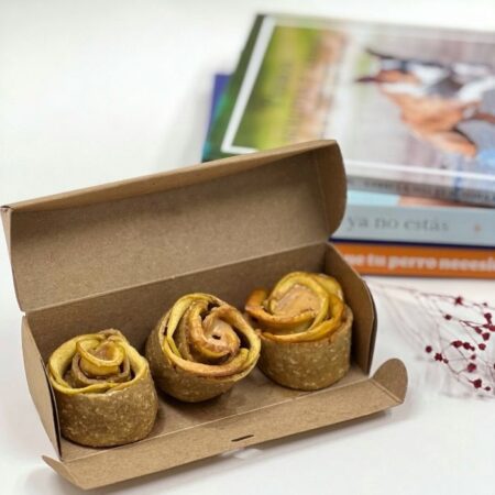 Primer plano de la mini caja con las 3 Rosas Frutales para perros, mostrando la textura crujiente y el relleno de crema de cacahuete artesan